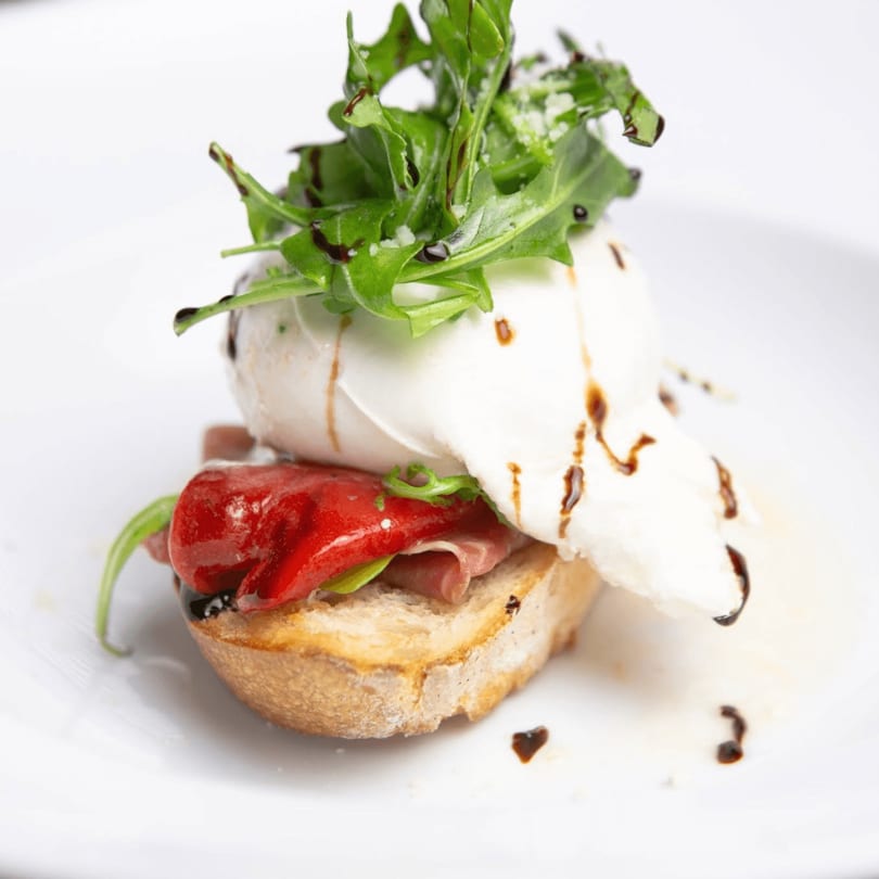 Toasted bread with prosciutto, roasted red pepper, burrata, arugula, and balsamic glaze.